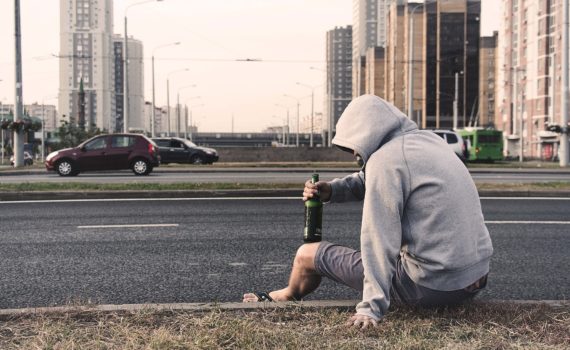 sitting on the side of the road with a beer